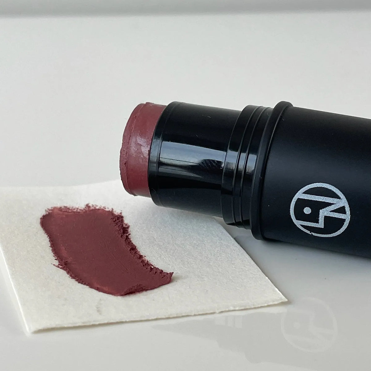 Lisa Noto Natural Radiance Stick lying with a mauve swatch on white paper — natural multi-use makeup
