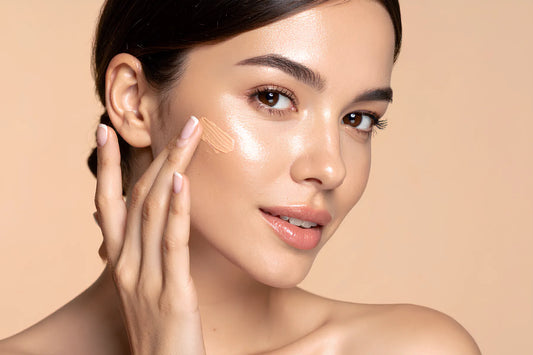 femme avec une peau mature qui applique une crème teintée ou fond de teint sur une peau propre et en santé.