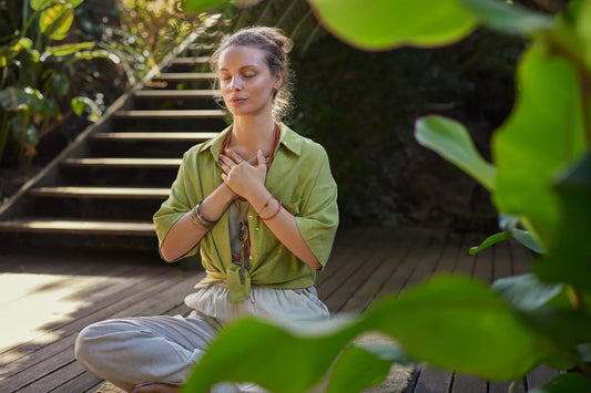 Woman practicing mindful breathing outdoors to support relaxation and overall wellness.