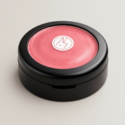 Baume lèvres et joues naturel Pastille Éclat Énergisant Watermelon dans un boîtier noir minimaliste sur fond gris pâle